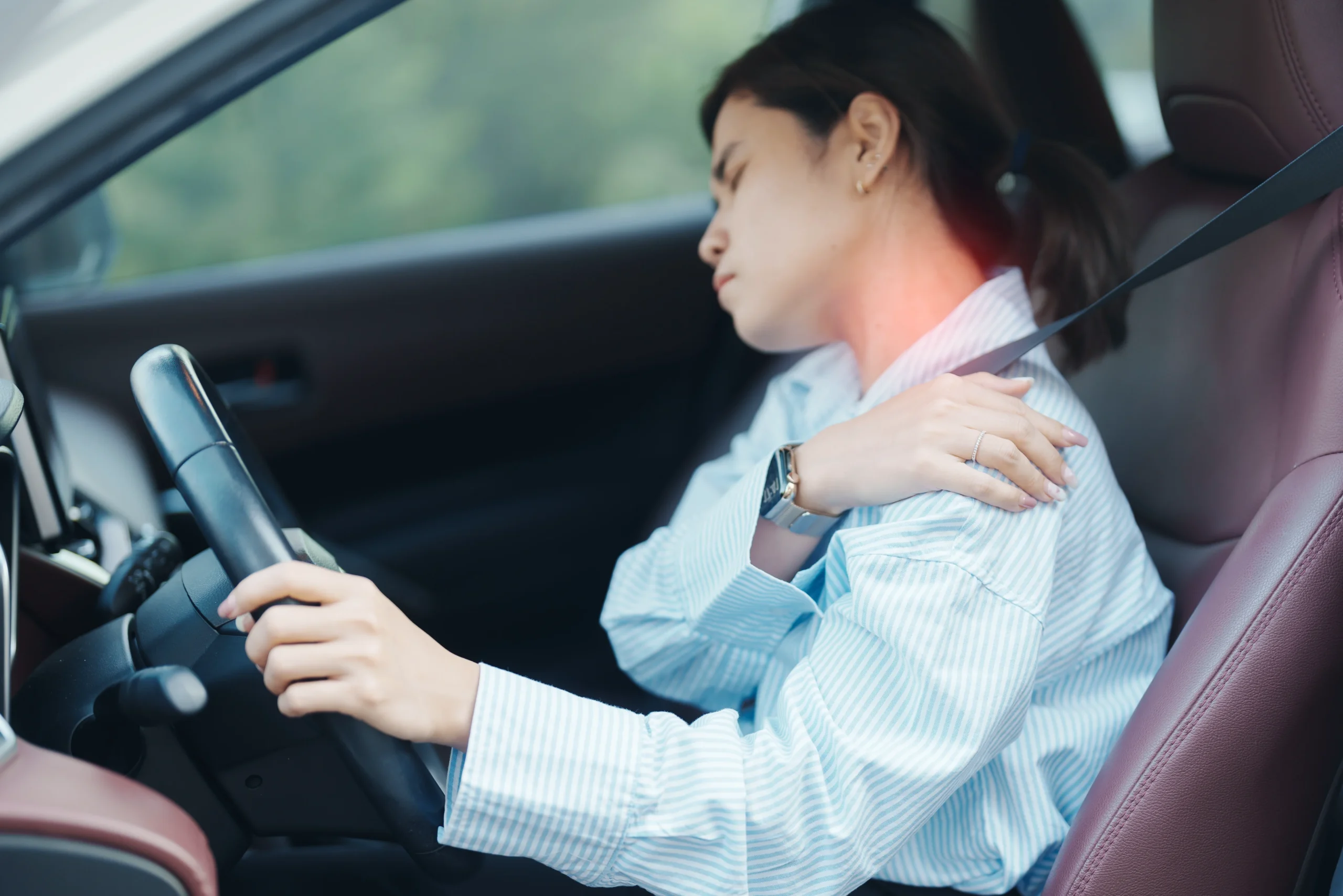 Woman driving with shoulder pain.